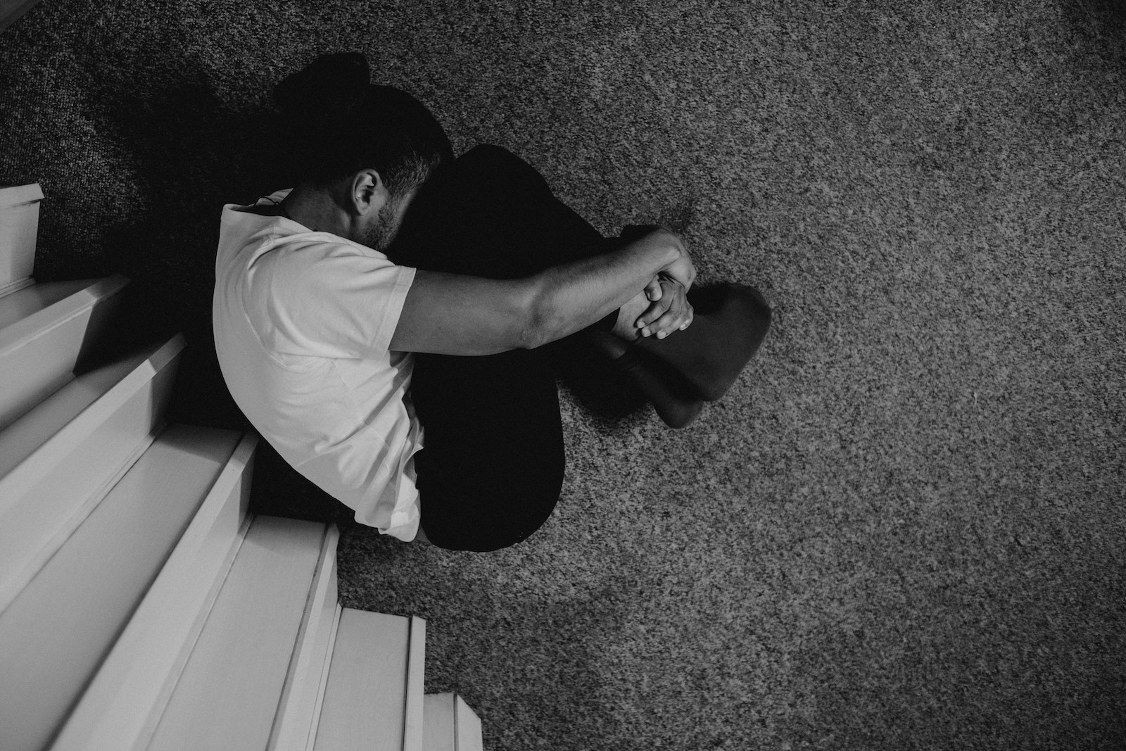 Man in White T-shirt Sitting on Floor