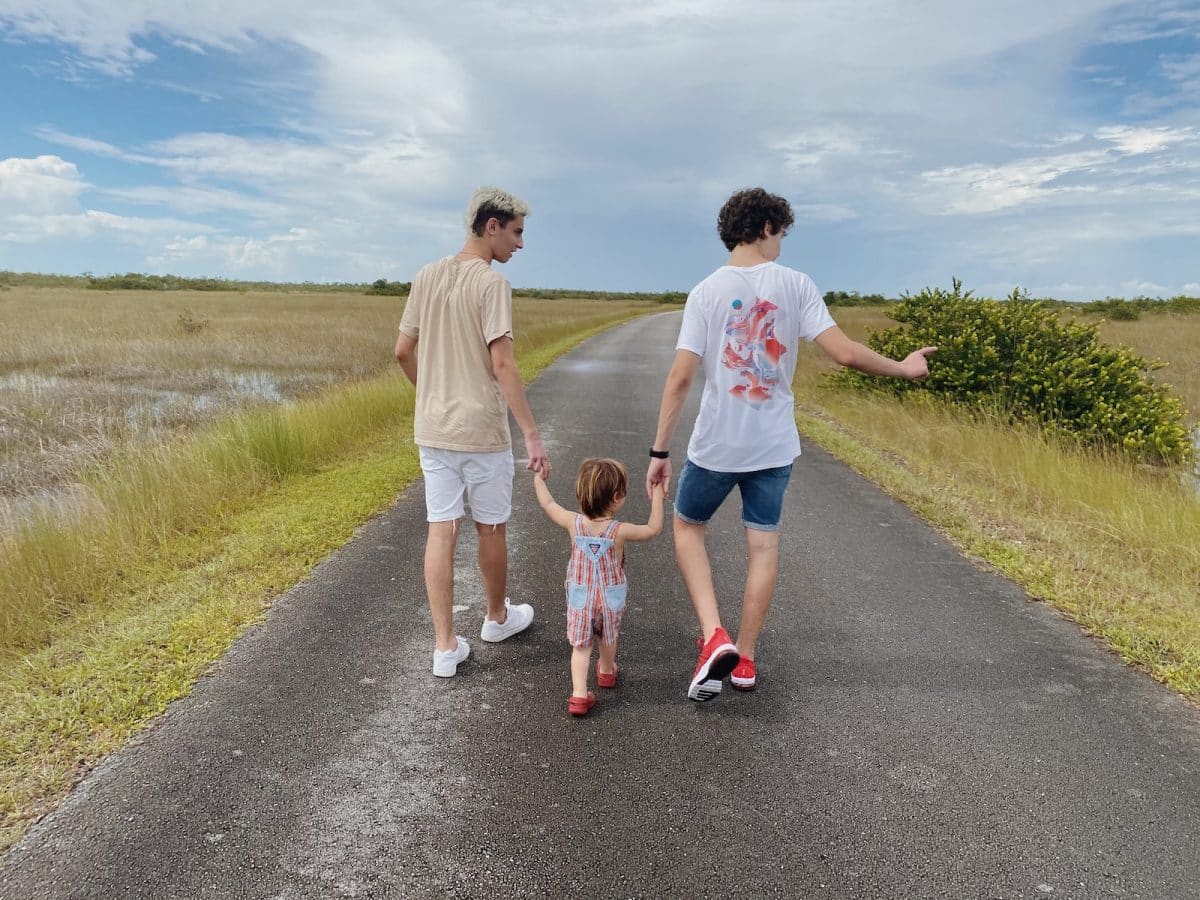 2 boys running on road during daytime